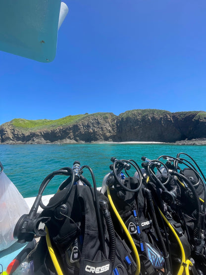 Scuba diving gear at the edge of a boat overlooking the turquoise water in Islas Catalinas.