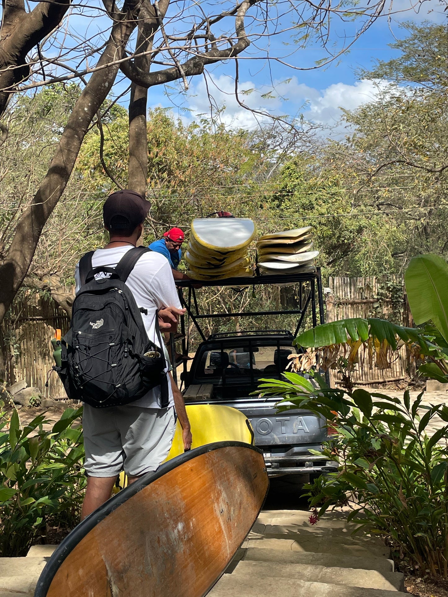 Small group travel participants stacking surfboards on a truck for surf lessons in San Juan Del Sur.