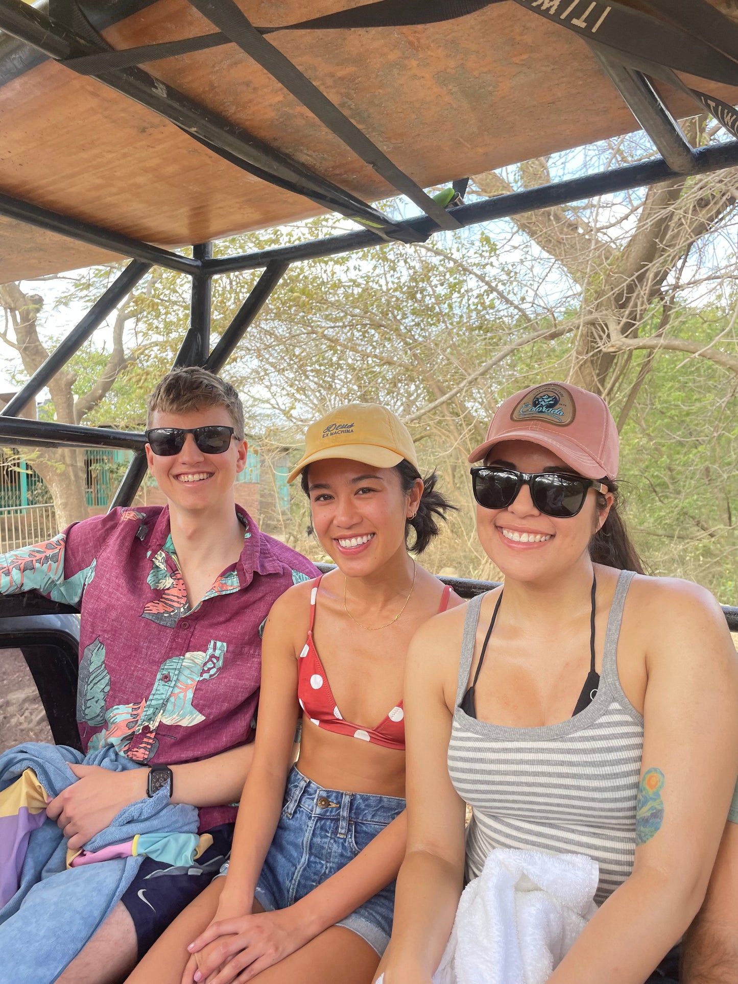 Three trip participants smiling on a truck on their way to surf lessons in San Juan Del Sur.