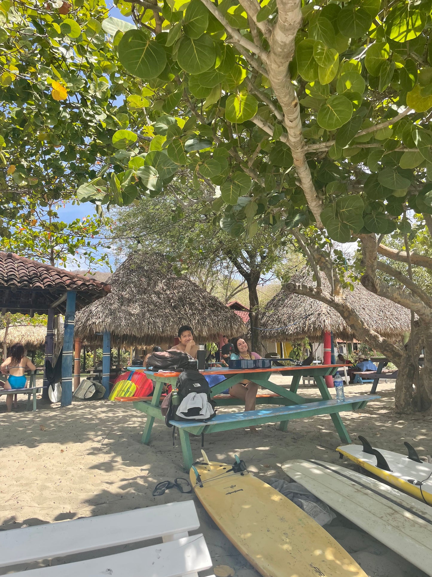 Trip participants relaxing on picnic tables after surf lessons in San Juan Del Sur.