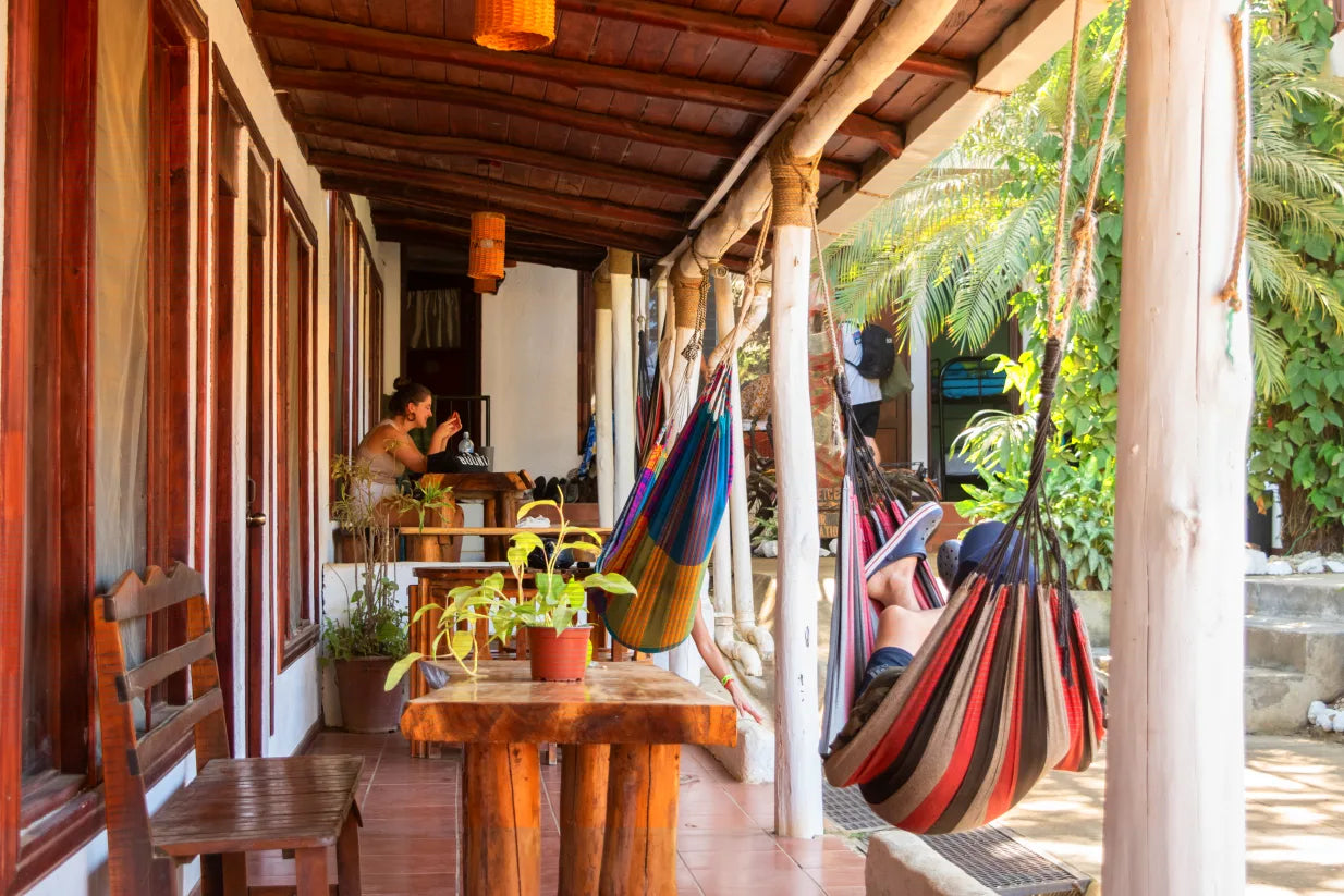 Group trip participants relaxing in hammocks at their hostel in Tamarindo.