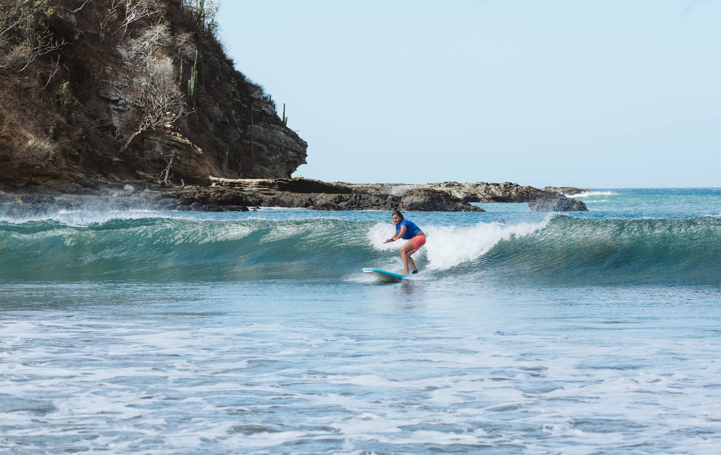 Girl surfing a wave during surf lessons in San Juan Del Sur.
