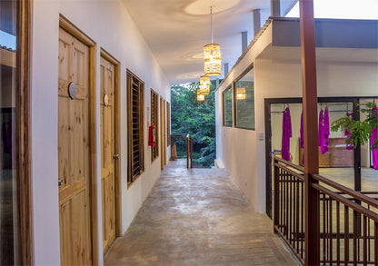 Outdoor hallway leading to hostel rooms at La Botella De Leche hostel in Tamarindo.