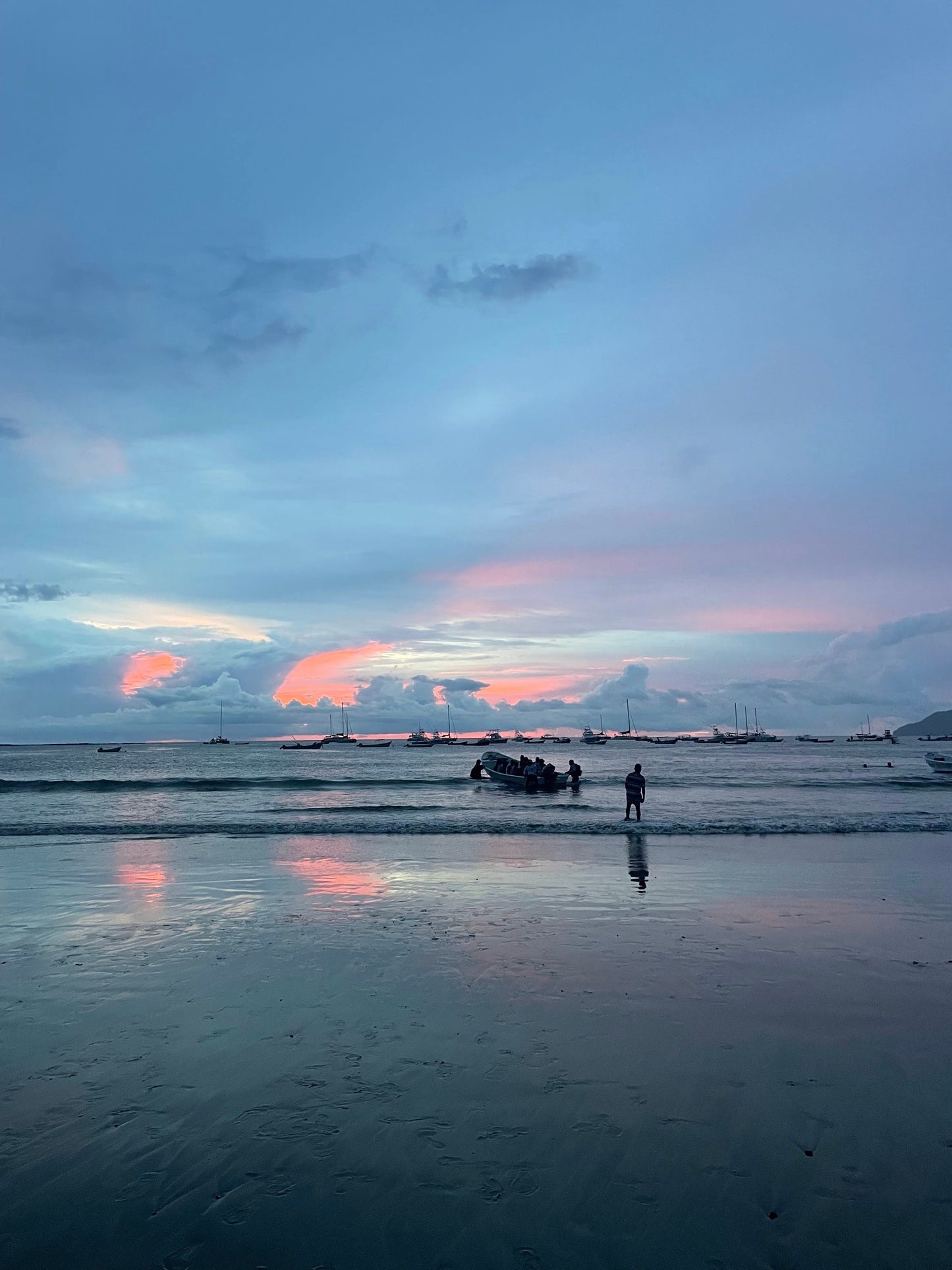 Boats floating in Tamarindo during a cotton candy sunset.