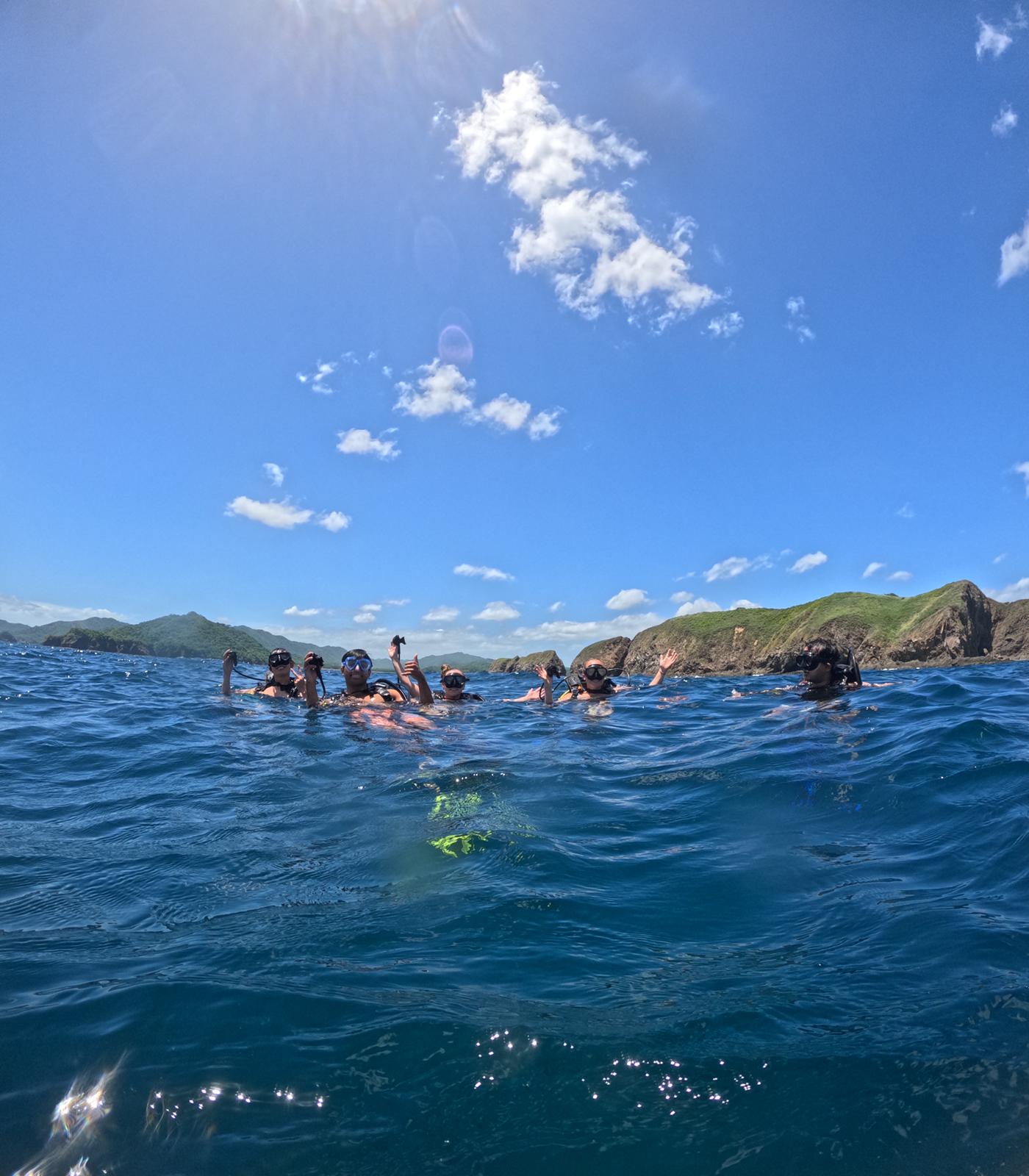 Small group travel participants smiling in their scuba diving gear in Islas Catalinas.