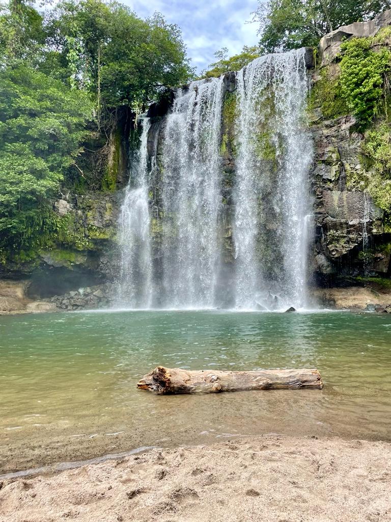 View from the sand of the Rio Celeste waterfall in Costa Rica during a group excursion.