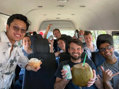 Small group trip participants with beers and coconuts in a van in San Juan Del Sur.