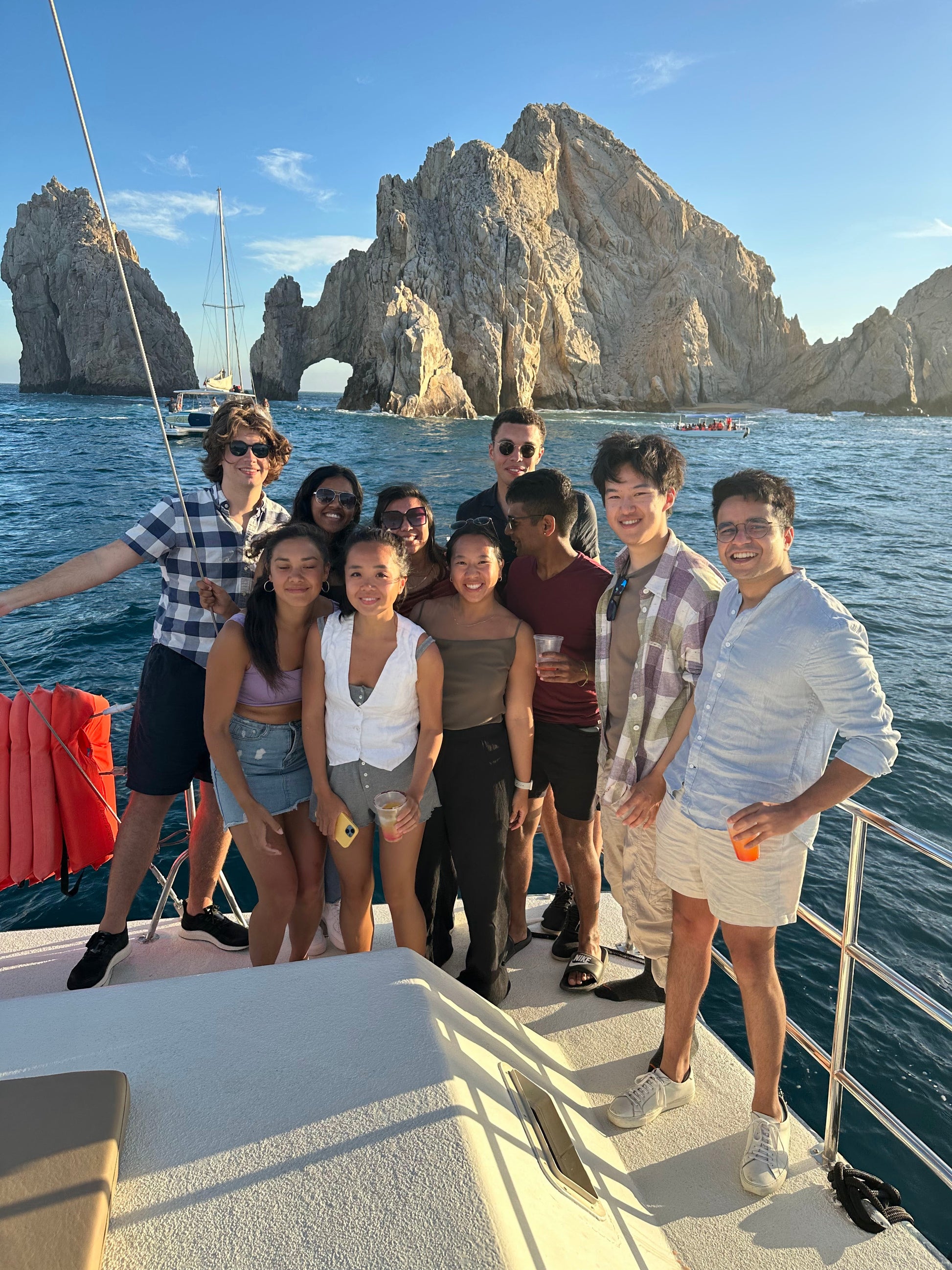 New friends smiling and drinking on a boat together in Los Cabos.