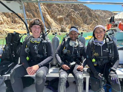 Three small group trip participants smiling before scuba diving in Los Cabos.