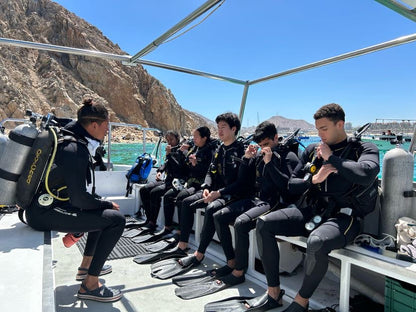 Small group trip participants on a boat in Los Cabos preparing to go scuba diving.