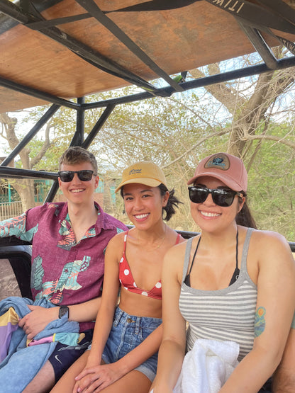 Three trip participants smiling on a truck on their way to surf lessons in San Juan Del Sur.