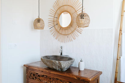 Bathroom sink with sun mirror in the Dreamsea Surf House accommodation.