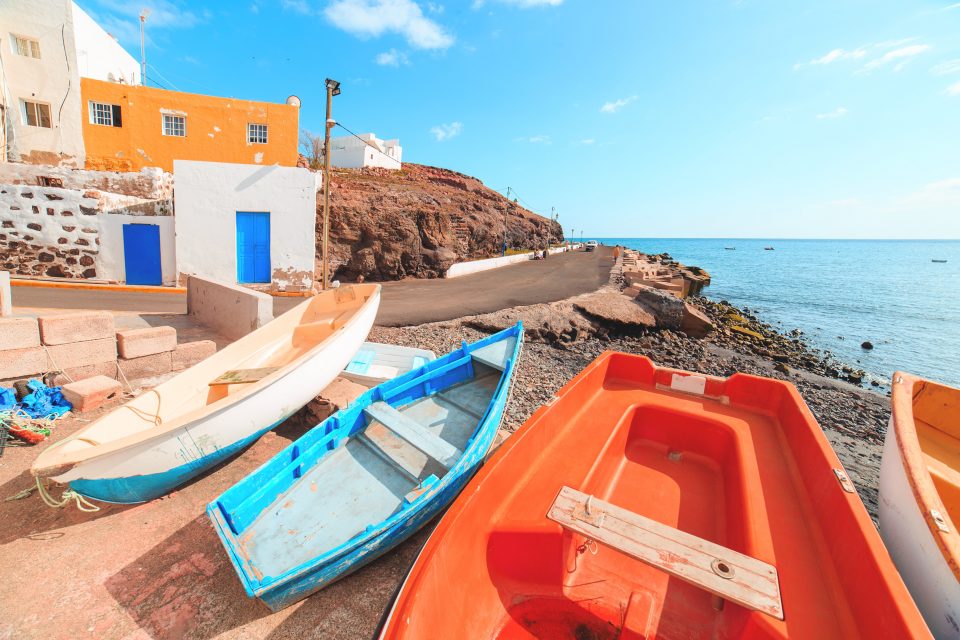 Small boats docked near the ocean and town in Fuerteventura Spain.