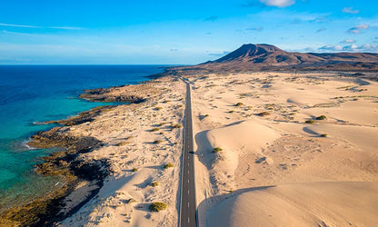 A highway between the ocean and sand dunes in Corralejo Fuerteventura.