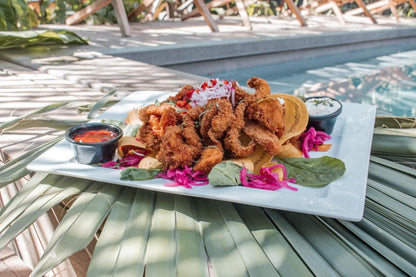 Plate of fried food with salsas near the pool at the Michanti Hotel during group travel.