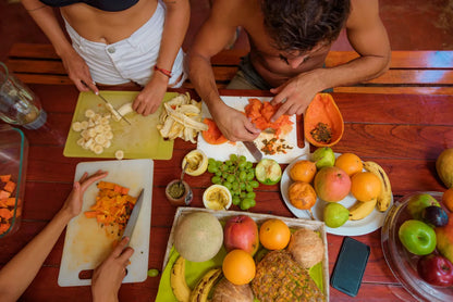 Small group travel participants cutting fruit on a bench in Tamarindo Costa Rica.