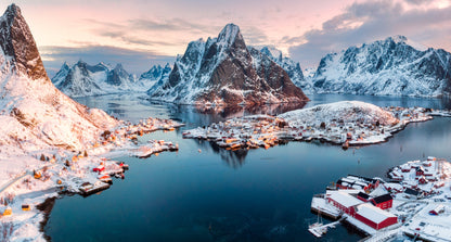 Landscape view of the snowy mountains along the water in Reine Norway.