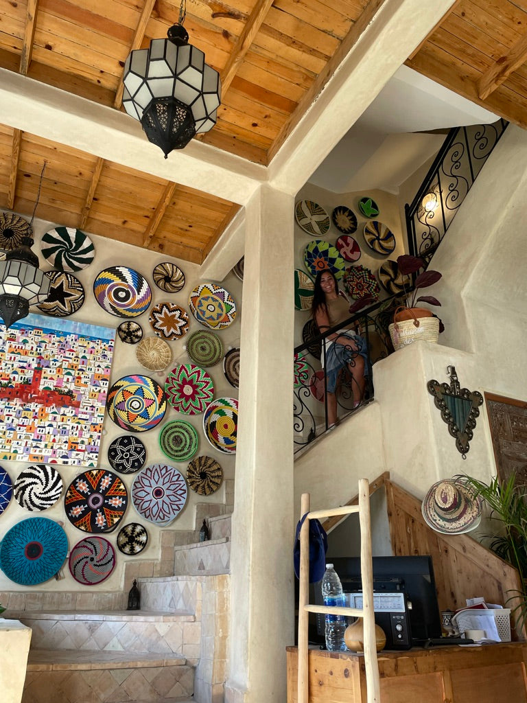Trip participant at the top of the Taghazout accommodation staircase near Moroccan style wall decor.
