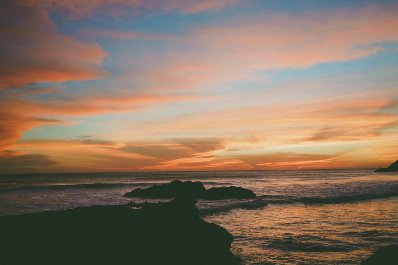Pink and blue sunset over the ocean rocks of El Zonte El Salvador.