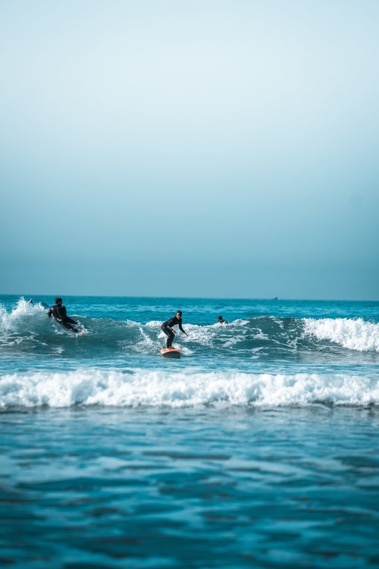 Small group trip participant surfing a wave in Taghazout.